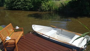 A wooden dock with a bench and a small boat.