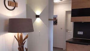 Et moderne køkken med et træskab, en vægmonteret lampe og en unik træskulptur.