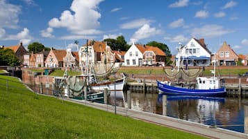 A canal with boats docked, surrounded by traditional houses with red roofs.
