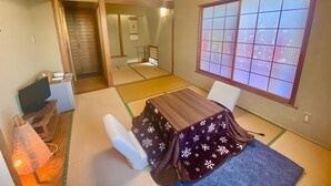 A traditional Japanese room with tatami flooring, a low table, and a shoji screen window.