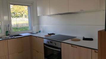Een koelkast, een oven, een vaatwasser, een eettafel