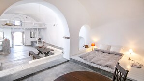 Um quarto espaçoso com uma grande mesa de jantar, uma cama com vista e uma área de cozinha.