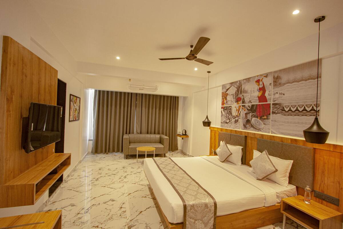 A modern hotel room with a large bed, a flat-screen TV, a ceiling fan, and a mural on the wall.