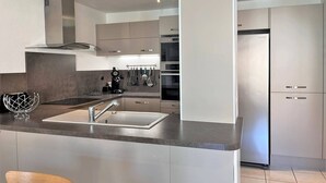 Een moderne keuken met een centraal eiland, roestvrijstalen apparatuur en een strak design.