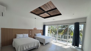A modern hotel room with two beds, a large window with a view of palm trees, and a ceiling with a wooden panel design. - Hotel Paseo del Sol (La Herradura)