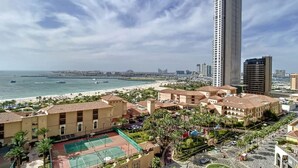 A coastal hotel with a beach view, a tennis court, and a parking area. - Lux 2 Bed l Stunning Sea View I Steps to JBR Beach I Sadaf 6 (Jumeirah Beach Residence)