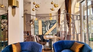 Un intérieur moderne avec deux fauteuils bleus, une table centrale et un élément décoratif mural.
