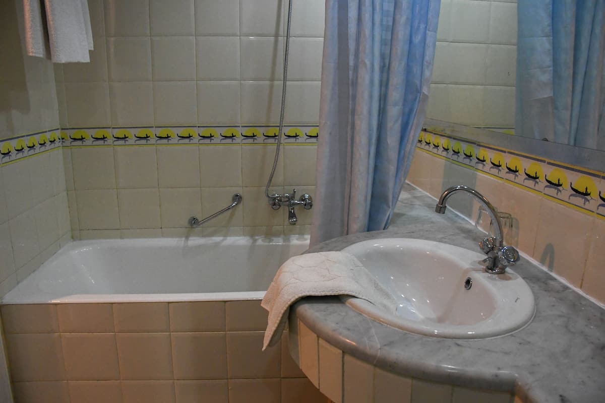 A bathroom with a bathtub, a sink, and a shower.