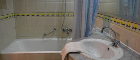 A bathroom with a bathtub, a sink, and a shower.