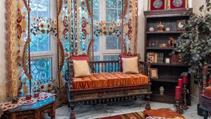 A traditional room with a wooden bed, ornate curtains, a bookshelf, and a window with a view. - Vesta - Mokattam Residence (Cairo)