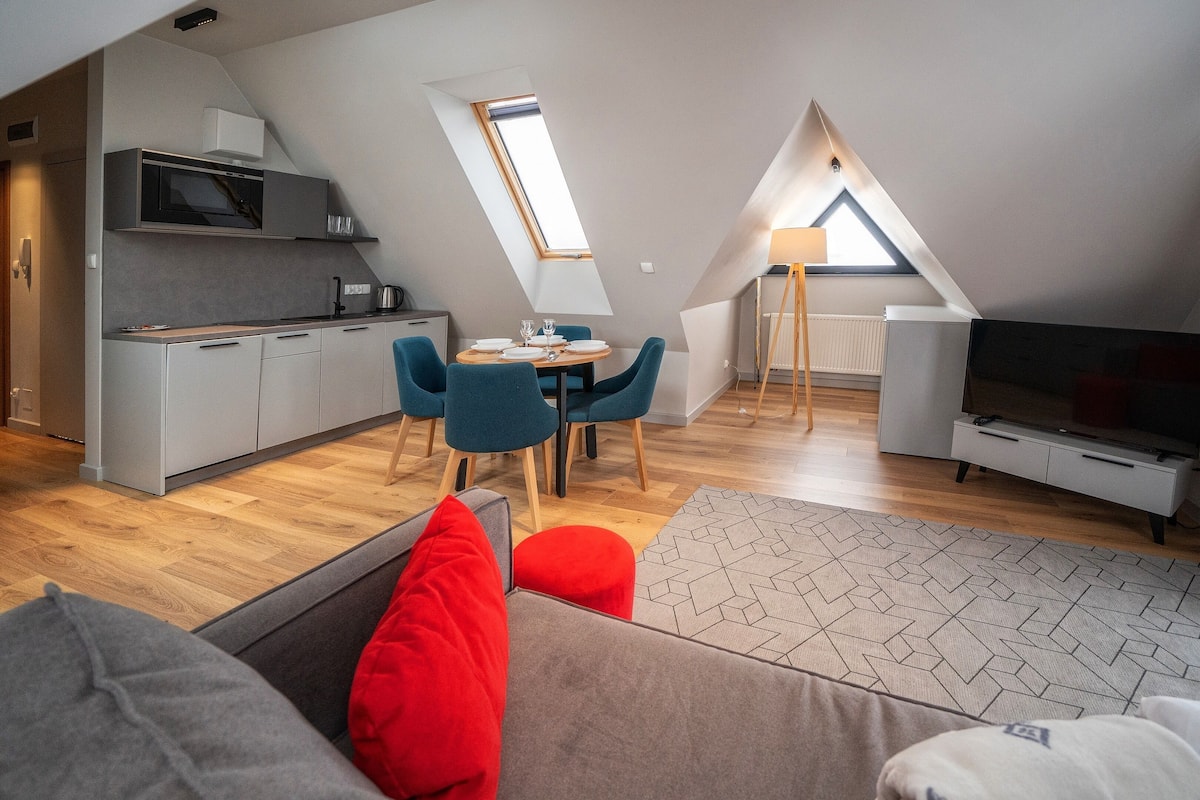 Um apartamento moderno estilo loft, com cozinha, sala de jantar e área de estar.