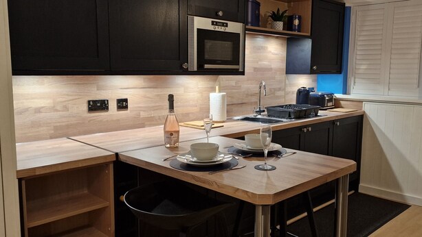 A compact kitchen with a wooden countertop, a microwave, a toaster, and a clock on the wall. - Hayling Hideaway, private self contained cosy annex near to beach (Hayling Island)