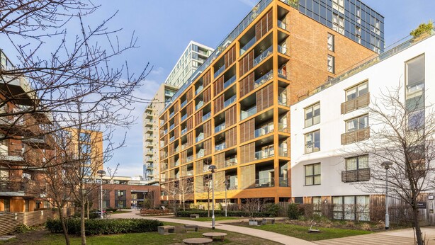 A multi-story residential building with a modern design, featuring balconies and large windows.
