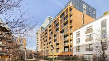 A multi-story residential building with a modern design, featuring balconies and large windows.