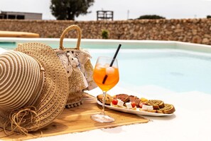 Relax by the pool with a refreshing drink and a selection of snacks.