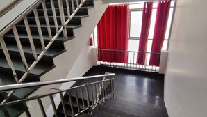 A staircase with metal railings leading to a landing. - Hotel Rivasa Regency (New Delhi)