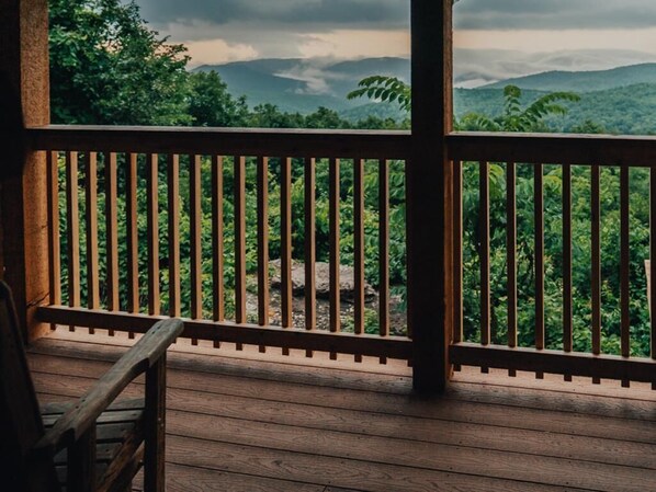 A wooden deck with a railing overlooking a lush green landscape with mountains in the distance. - Buffalo River Cabin w/ Hot Tub (Ponca)