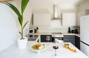 Departamento urbano | Cocina privada | Refrigerador con congelador, microondas, horno y parrilla de estufa 