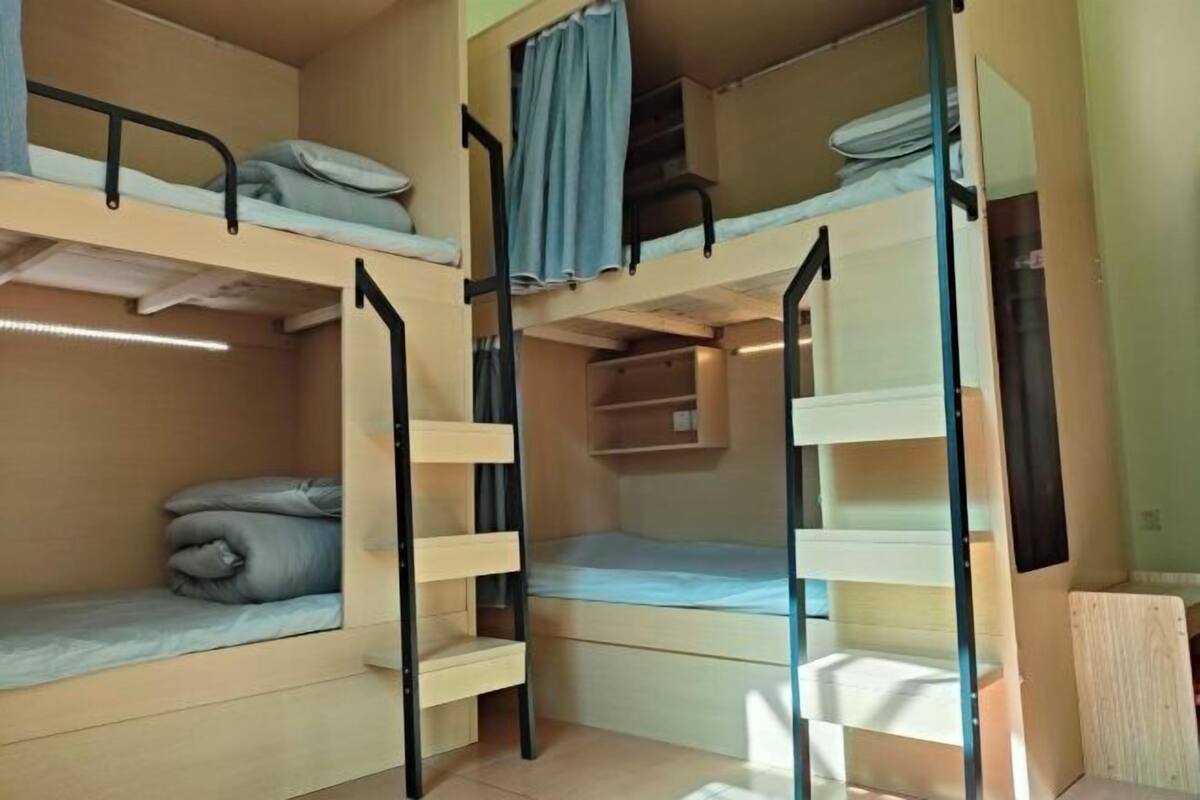 A bunk bed room with a small desk and shelves.