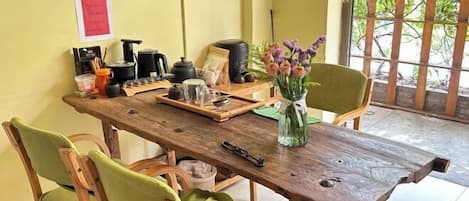A wooden dining table with chairs, a tray, and a vase with flowers.