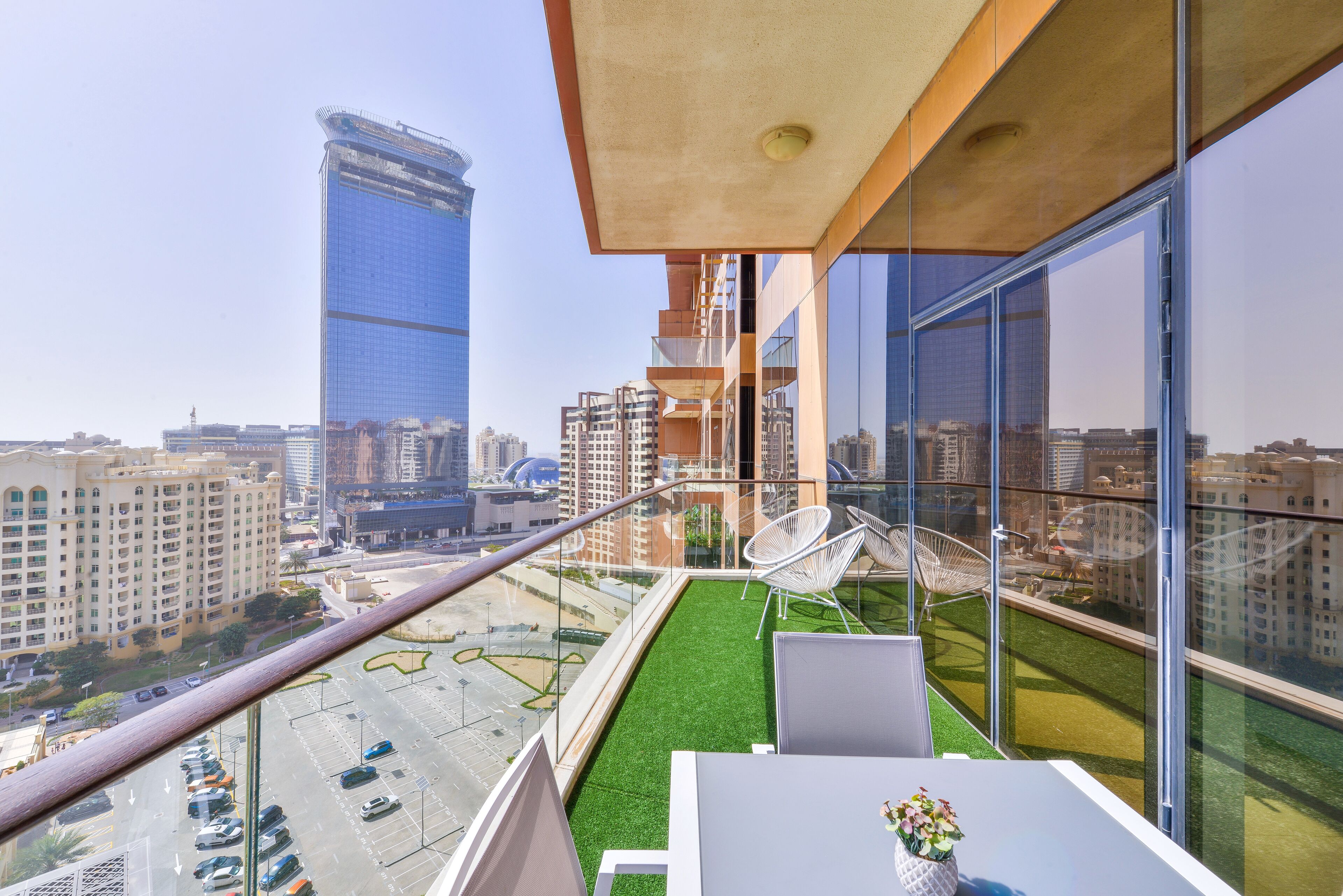 Ein moderner Balkon mit Blick auf eine Stadtlandschaft, einschließlich hoher Gebäude und eines Parkplatzes.
