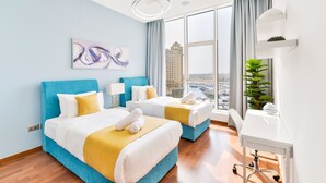 A hotel room with two beds, a desk, a large window with a city view, and a modern art piece on the wall. - Tiara - Luxury Palm Jumeirah (Dubai)