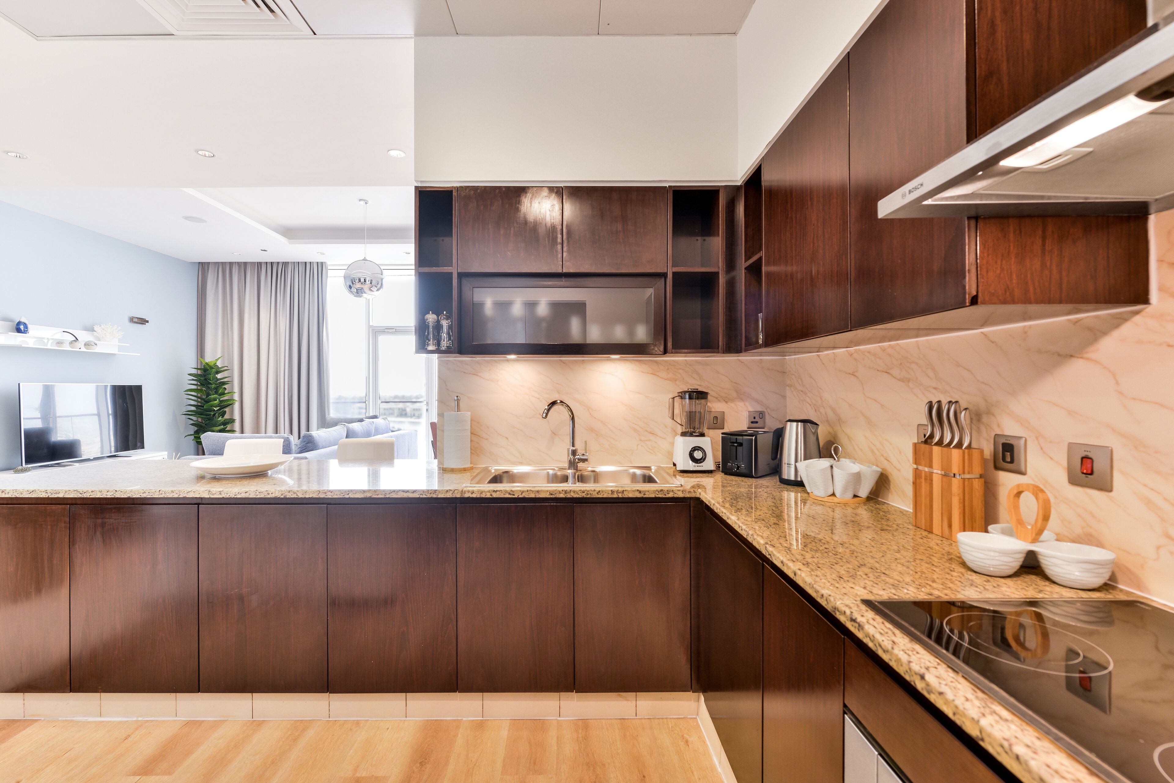 A modern kitchen with dark wood cabinets, a granite countertop, and stainless steel appliances.