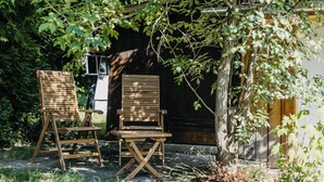 Two wooden chairs and a small table in a garden area with a wooden fence and greenery. - Dahuam am Weinberg - Inner warmth (Winten)