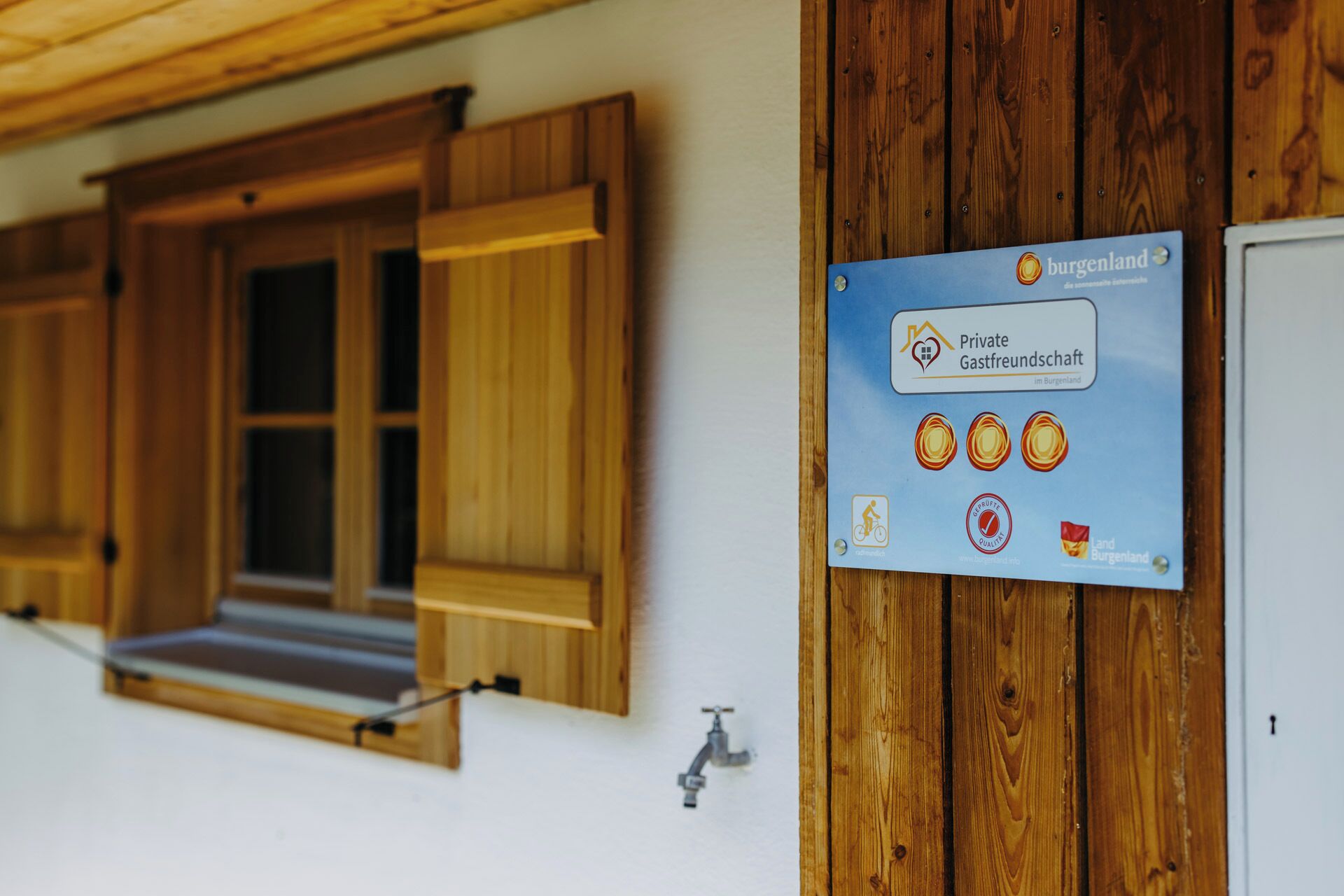 A sign for a private guesthouse in Burgenland, Austria, with a bicycle symbol indicating bike-friendly accommodation.