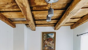 A room with a wooden ceiling, a bed with green pillows, a small bedside table with a lamp, and a painting on the wall. - Dahuam am Weinberg - Inner warmth (Winten)