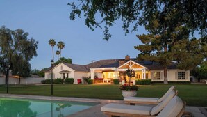 A house with a swimming pool, outdoor seating, and a well-maintained lawn. - Chateau D`Arcadia - A French Inspired Luxury Home (Scottsdale)