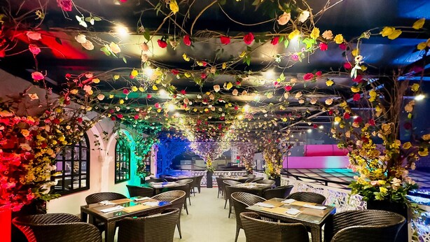 A restaurant with wicker furniture and a central fountain. - Rose Palace Hotel Gulberg (Lahore)
