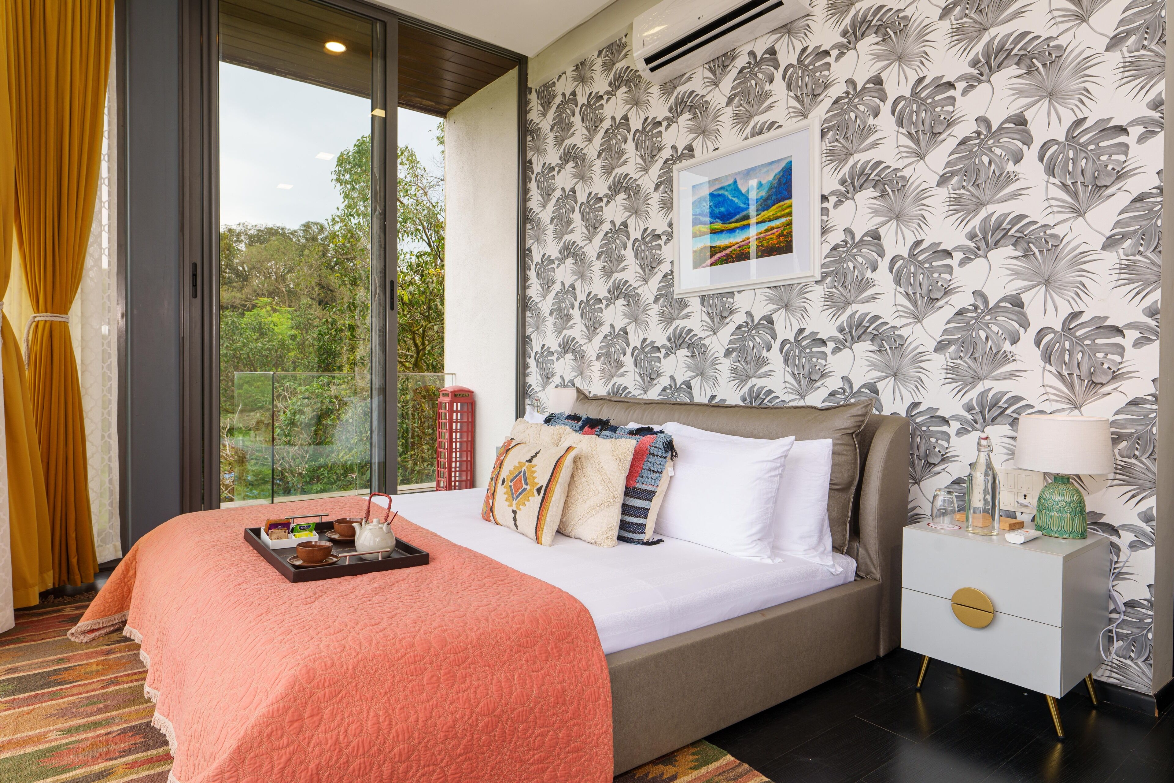 A modern hotel room with a large bed, a nightstand with a lamp, and a window with curtains.