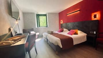 A modern bedroom with a large bed, a desk, and a window.