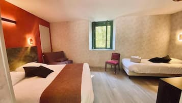A hotel room with two beds, a chair, a small table, and a window.