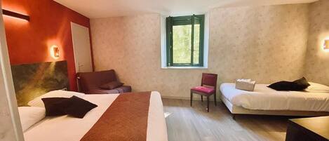 Habitación de hotel con dos camas, una silla, una mesita y una ventana.