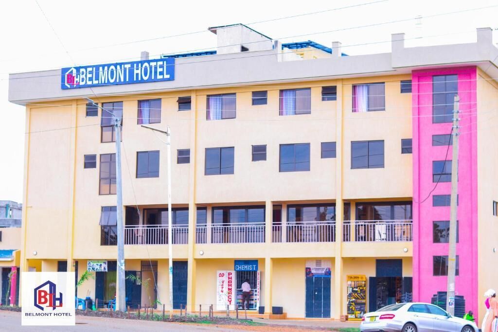 A multi-story hotel with a yellow facade and a pink section on the right.