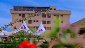 A hotel building with a sign reading "BELMONT HOTEL" and two tents with the same logo.