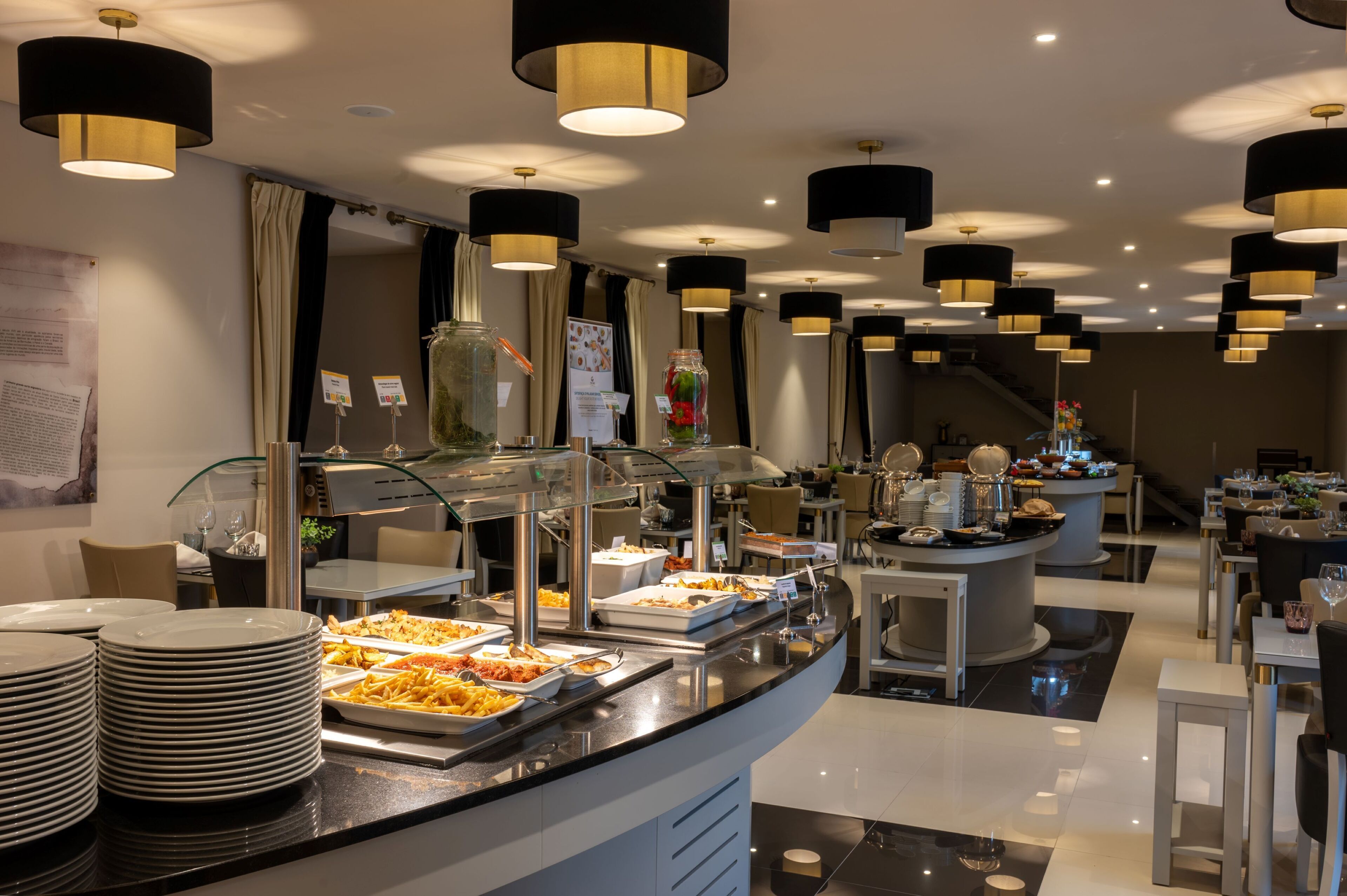 A buffet area with multiple food stations, a glass display case, and a seating area with tables and chairs.