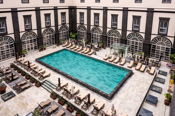 A rooftop pool area with sun loungers and a clear blue pool. - Vila Gale Collection S. Miguel Hotel (Ponta Delgada)