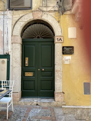 A green double door with a metal archway, a mailbox, and a sign for 'Elegance B&B'. - Taormina B&B (Taormina)