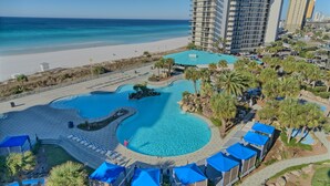 A resort with a large pool, beach access, and a view of the ocean.