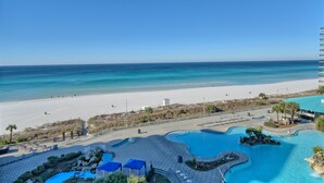 A resort with a swimming pool, beach, and ocean view.
