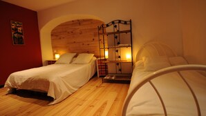 Un dormitorio con dos camas, suelo de madera y cabecero de madera.