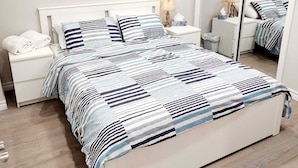 Un dormitorio con cama, mesitas de noche, un espejo y una ventana.