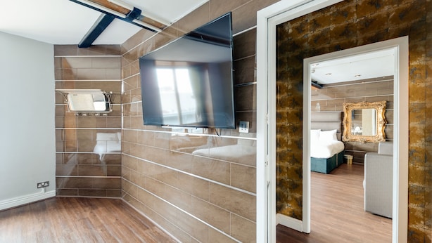 Une salle de bain moderne avec un grand miroir, un meuble-lavabo et un espace douche.