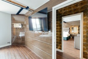 Une salle de bain moderne avec un grand miroir, un meuble-lavabo et un espace douche.