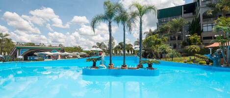 Una piscina techada, una piscina al aire libre, sombrillas