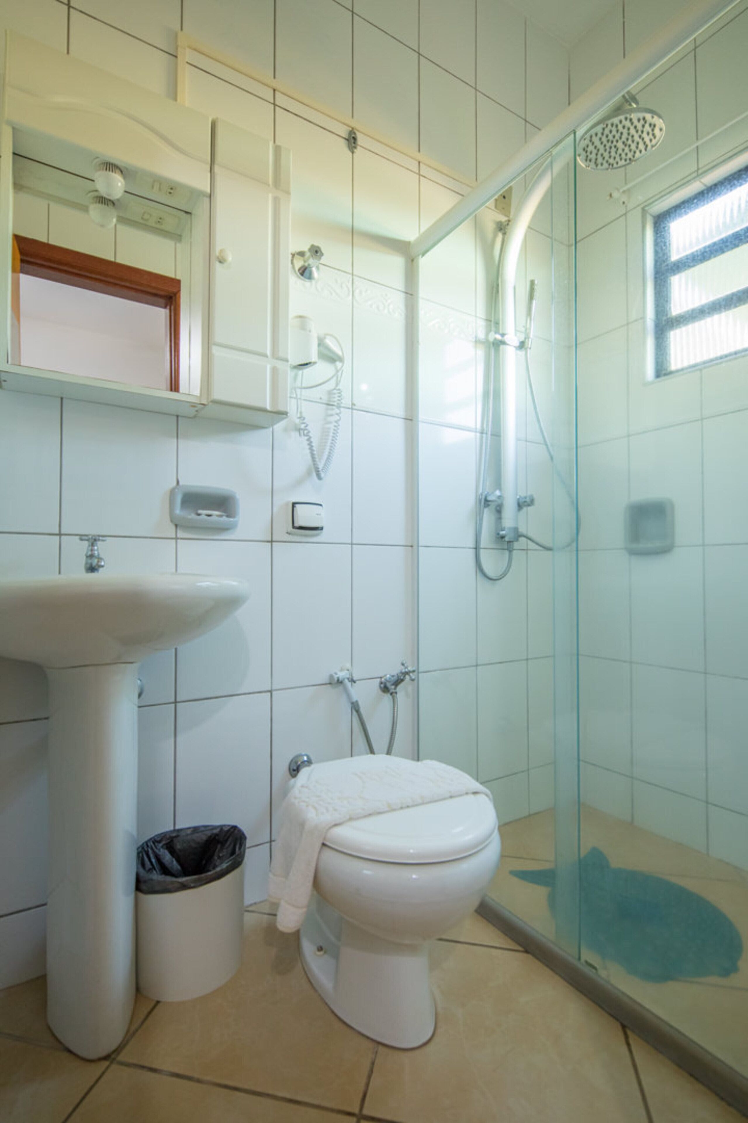 A bathroom with a sink, toilet, and glass-enclosed shower.