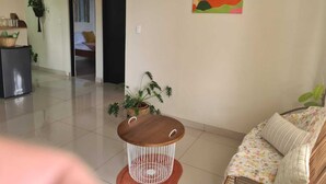 A living room with a round wooden table, a sofa, and a colorful abstract painting on the wall. - New apartment 5 minutes from the central park (La Fortuna)